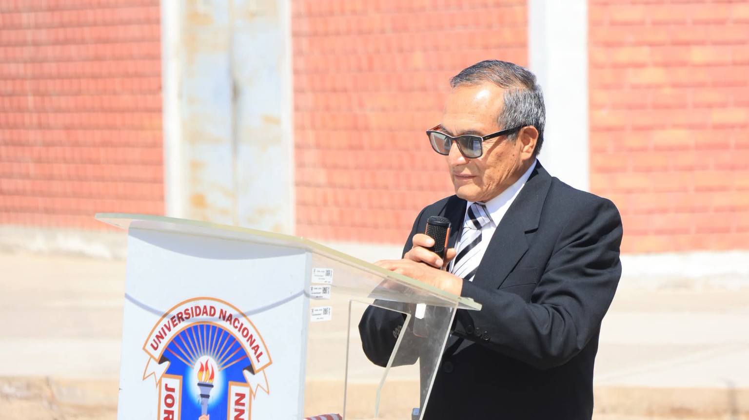 Intervención en una ceremonia desde el atril de la UNJBG